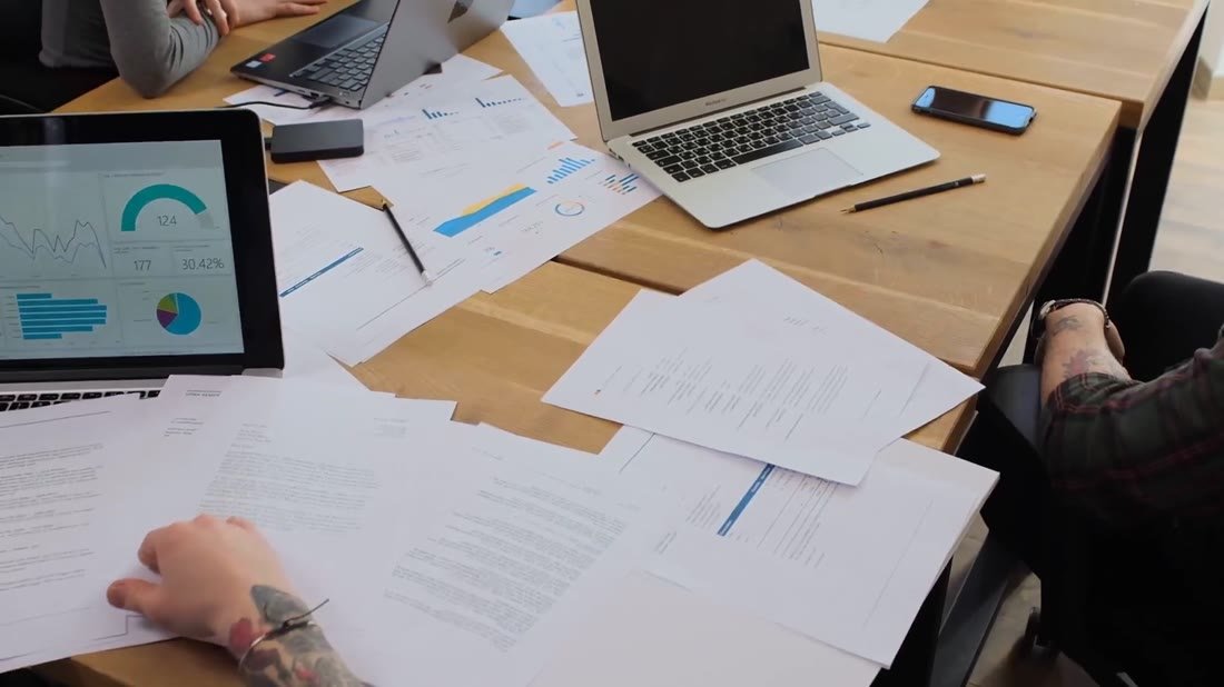 Equipo de marketing revisando materiales y resultados en una mesa de trabajo