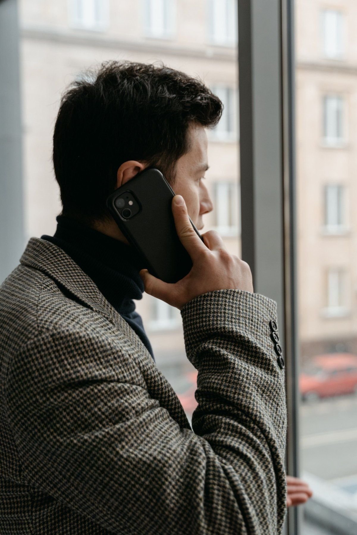 Profesional hablando por teléfono junto a una ventana